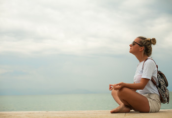 Wall Mural - Happy young woman meditating at seacoast