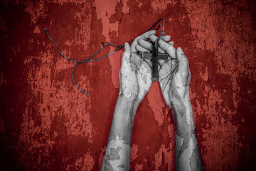 Wall Mural - Hands of praying young woman on a grunge background.