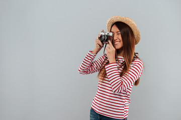 Wall Mural - Smiling asian woman in sweater and hat making photo