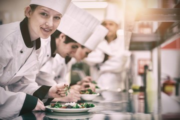 Happy chef looking up from preparing salad