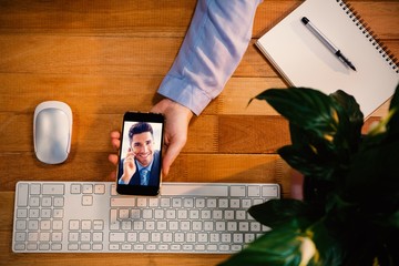Poster - Composite image of businessman sitting making a call smiling at
