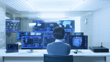 Fototapete - Back View of the IT Engineer Working with Multiple Monitors Showing Graphics, Functional Neural Network. He Works in a Technologically Advanced System Control Data Center.
