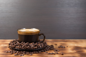 Coffee cup and saucer on a wooden table. Dark background.