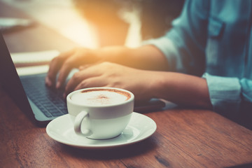 Wall Mural - Hands typing on laptop in coffee shop