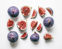 Fresh Figs. Food Photo. Creative Scheme Of The Whole And Sliced Figs On A White Background, Inscribed In A Rectangle. View From Above. Copy Space