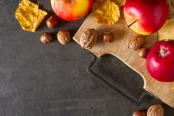 Autumn meal apples, nuts, pumpkin and yellow leaves. Dark backgr