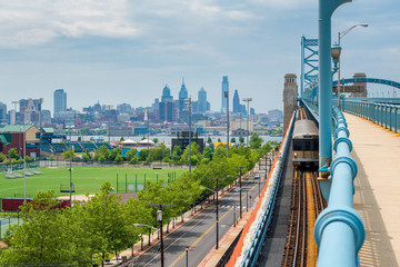 Wall Mural - Skyline of Philadelphia, Pennsylvania, USA as seen from Camden New Jersey, featuring the Delaware River and Benjamin Franklin Bridge
