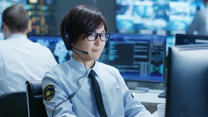 Leinwandbilder - In the Security Command Center Officer at His Workstation Monitors Screens and Communicates with Patrols through Headset. He is Part of the Surveillance Team. 