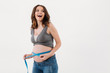© Drobot Dean - Portrait of a cheerful excited pregnant woman measuring her belly