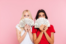 Two Surprised Women Hiding Behind The Money