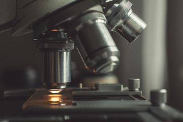 Wall Mural - Close-up shot of microscope with metal lens at laboratory.