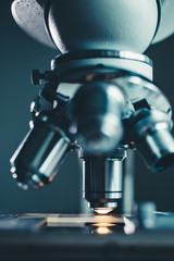 Wall Mural - close-up shot of microscope with metal lens at laboratory.