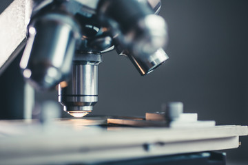 Wall Mural - close-up shot of microscope with metal lens at laboratory.
