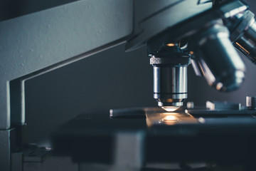 Wall Mural - close-up shot of microscope with metal lens at laboratory.
