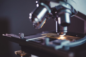 Wall Mural - close-up shot of microscope with metal lens at laboratory.