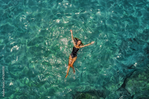 Summer image of beautiful girl swimming and lying on the back in the ...