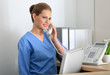 © Africa Studio - Young female receptionist talking on the phone in hospital