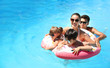 © Africa Studio - Happy family with inflatable donut in swimming pool