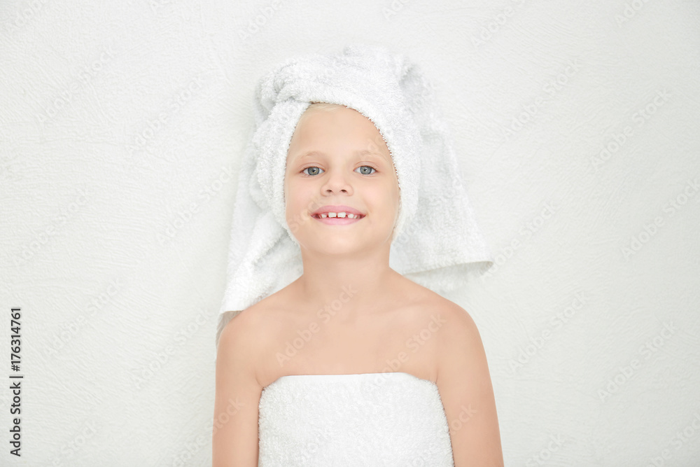 Little cute girl with towel on head against light background