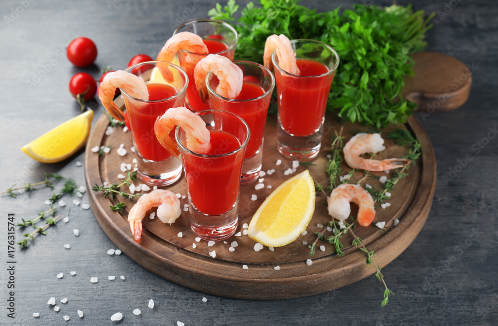 Composition with shrimps and tomato sauce in glasses on table