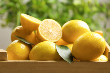 Wooden crate with fresh lemons, closeup