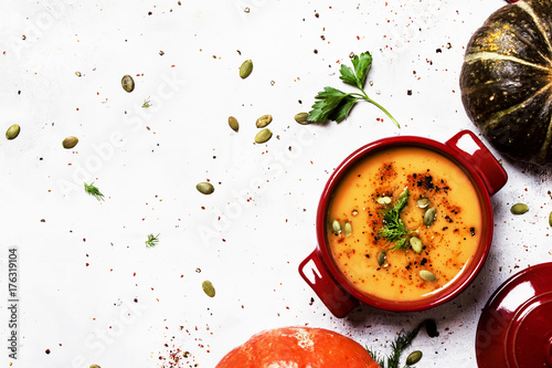 Fotografie, Obraz Spicy pumpkin soup in a serving pan, top view