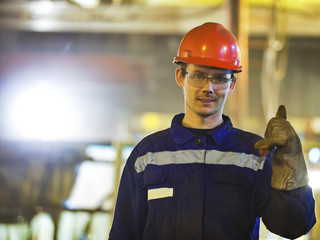 Workers fitters and welders in protective clothing and a helmet.