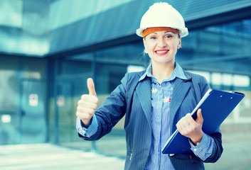 Employee woman in helmet with paper documents