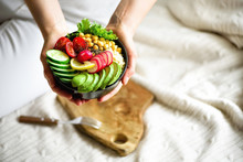 Girl In White Jeans Holds In Hands Fork, Vegan Breakfast Meal In Bowl With Avocado, Quinoa, Cucumber, Radish, Salad, Lemon, Cherry Tomatoes, Chickpea, Chia Seeds. Top View, Copy Space. Clean Eating.