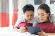 © vichie81 - Couples lying using tablet on bed