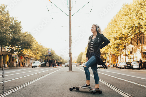 Plakat Młoda kobieta słucha muzyka przy ulicą