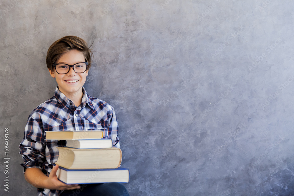 Cute teenage school boy holding books Stock Photo | Adobe Stock