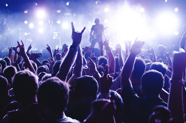 concert crowd. silhouettes young people in front of bright stage lights. band of rock stars