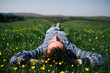 © Nabi Tang/Stocksy - Handsome young man on the grass field on the hill in spring