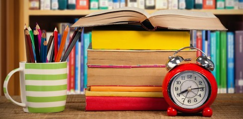 Poster - Composite image of stack of books by mug with colored pencils