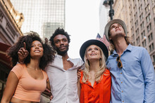 Group Of Friends In The Streets Of New York Pointing And Looking Up