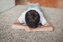 Young Boy Laying Upset On The Floor