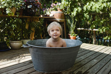 Little Short-haired Girl Sits Washing Outside In An Old-fashioned Tin Tub.