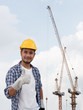 © Mongkolchon - The portrait of Asian male engineer. The construction project engineer is observing tower crane operation at construction site. The isolated image of engineer with clipping path. Double exposure image