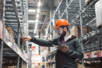 Warehouse manager checking his inventory in a large warehouse