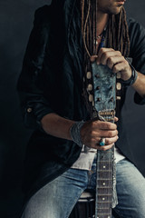 gypsy hippie styled young man with guitar close up portrait