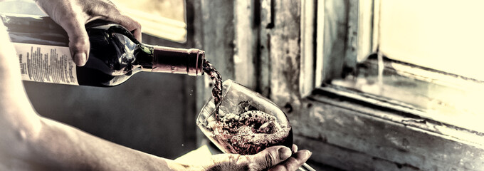 toned. Pouring wine on a old background