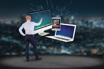 Sticker - Businessman in front of a wall with Computer and devices displayed on a futuristic interface - Multimedia and technology concept