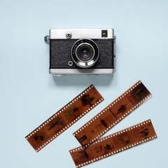 An old camera and a photographic film on a blue background.