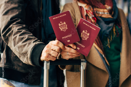 Zdjęcie XXL Para ręka trzyma paszport. Podróżnik z koncepcją bagażu podróży. Turystyka ludzi. Biometryczne paszporty mołdawskie