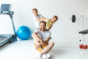 Canvas Print - father with sons exercising together