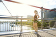 © Westend61 - Sportive young woman standing on bridge