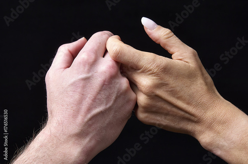 Zdjęcie XXL Męskie i żeńskie ręki wpólnie na czarnym tle