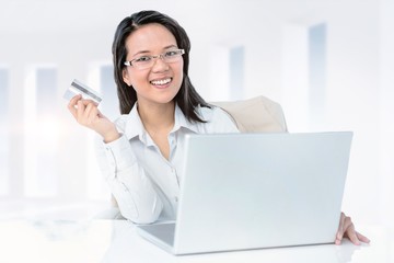Poster - Composite image of smiling businesswoman holding credit card