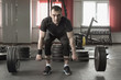 © lenblr - Young man doing exercise with a barbell in gym.